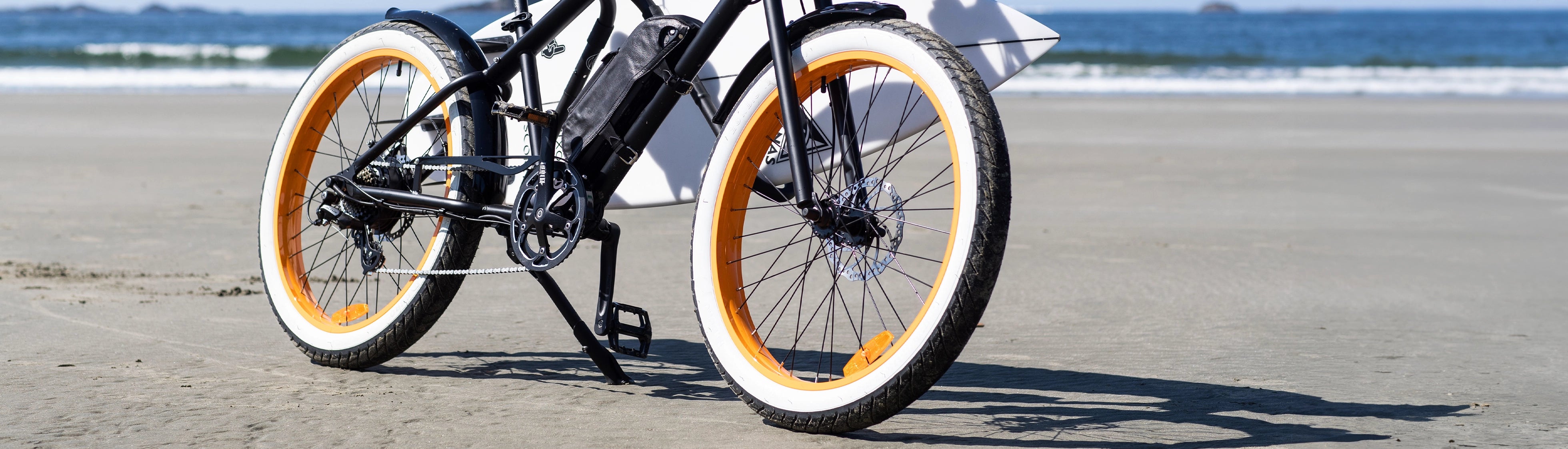Person riding eBike on beach with ocean in the background